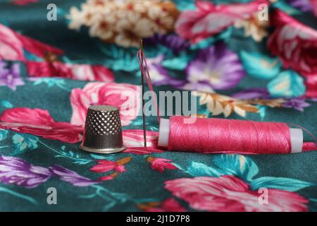 Spool of Pink Thread and Thimble on Vintage Pink Satin and Feather Fabric  Stock Photo - Alamy