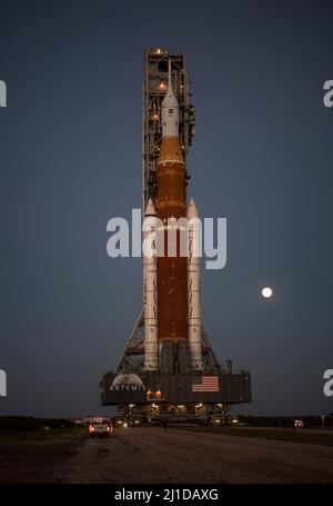 The Moon is seen rising behind NASAs Space Launch System (SLS) rocket with the Orion spacecraft aboard atop a mobile launcher as it rolls out to Launch Complex 39B for the first time, Thursday, March 17, 2022, at NASAs Kennedy Space Center in Florida. Ahead of NASAs Artemis I flight test, the fully stacked and integrated SLS rocket and Orion spacecraft will undergo a wet dress rehearsal at Launch Complex 39B to verify systems and practice countdown procedures for the first launch. Mandatory Credit: Aubrey Gemignani/NASA via CNP Stock Photo