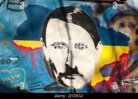23 March 2022, Czech Republic, Prag: On the so-called John Lennon Wall in Prague, an unknown person has depicted Russian President Vladimir Putin as Adolf Hitler in view of the Ukraine war. Above it, on March 23, 2022, is written in Czech the slogan 'valka je vul' - literally 'War is a horndog'. What is meant by this is that war is nonsense. The Lennon Wall on Prague's Lesser Town has been inscribed with ever-changing political messages since the 1980s. It commemorates the Beatles singer John Lennon, one of the icons of the peace movement. (to dpa 'Are there parallels between Putin and Hitler? Stock Photo