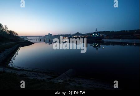 Kiel, Germany. 25th Mar, 2022. The sun rises over the Kiel Canal behind the high bridge in Holtenau. The annual balance PK General Directorate the General Directorate of Waterways and Shipping gives the traffic figures for the year 2021 for the Kiel Canal. Credit: Axel Heimken/dpa/Alamy Live News Stock Photo