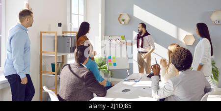 Business team listening to coach making presentation on teamwork and corporate management Stock Photo