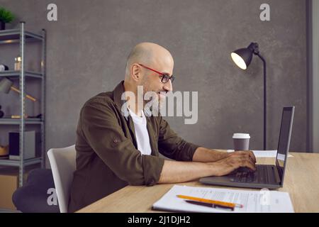 Smiling man freelancer work online on laptop Stock Photo