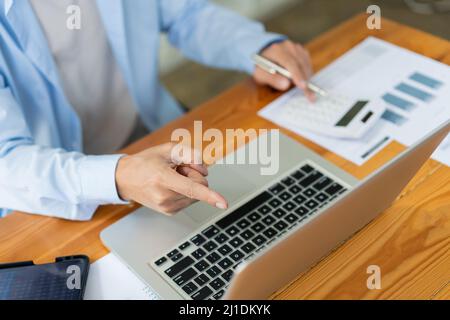 Business analyst concept the accountant using a calculator to estimate the amount of profits. Stock Photo