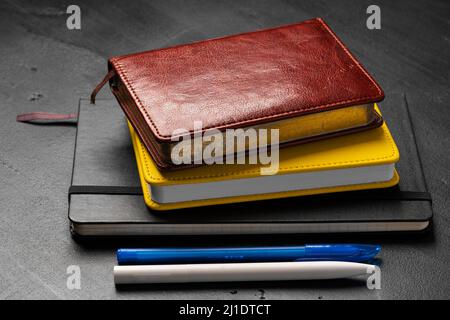 Three notepads on a black table close up Stock Photo