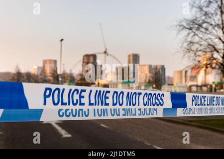 Blue and White POLICE LINE DO NOT CROSS cordon tape at the scene of a crime in the UK Stock Photo