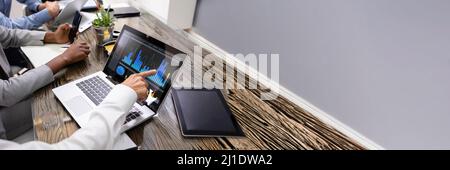 Side View Of Businesspeople Examining Graph On Computer At Workplace Stock Photo
