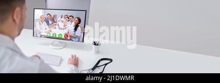 Young Male Doctor Video Chatting On Laptop In Clinic Stock Photo