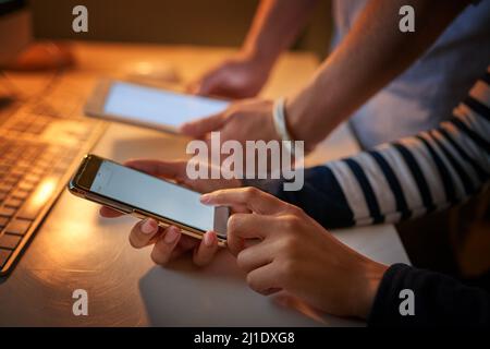 Cracking codes on our touch screens. Shot of unrecognizable computer programmers using different devices in the office. Stock Photo