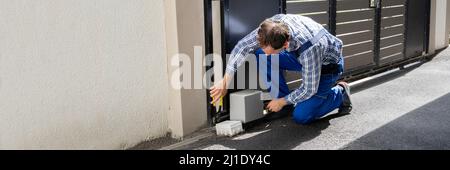 Repairman Fixing Broken Automatic Door In Building Stock Photo