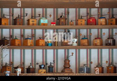 Variety of hand crank coffee grinders on display shelves. Stock Photo