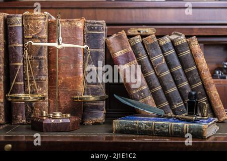 Compilation of old books on wooden desk and writing pen. Stock Photo