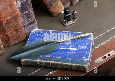 Compilation of old books on wooden desk and writing pen. Stock Photo