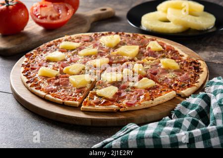Hawaiian pizza with pineapple,ham and cheese on wooden table Stock Photo