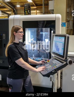 08.03.2022, Germany, North Rhine-Westphalia, Oberhausen - Trainee woman in metalworking professions. Trainee machinist at a CNC machine tool in the MA Stock Photo