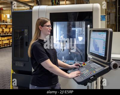 08.03.2022, Germany, North Rhine-Westphalia, Oberhausen - Trainee woman in metalworking professions. Trainee machinist at a CNC machine tool in the MA Stock Photo