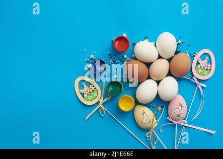 Design template for easter with eggs and paints on a blue background Stock Photo