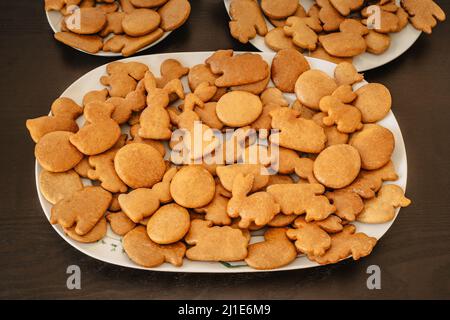 Handmade Easter gingerbread cookies in white plate on dark table.Spring symbols made from gingerbread.Homemade cookies.Easter bunny,rabbit,eggs and du Stock Photo