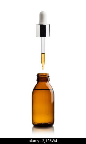 Cosmetic bottle of essential oil with pipette dripping oil Stock Photo