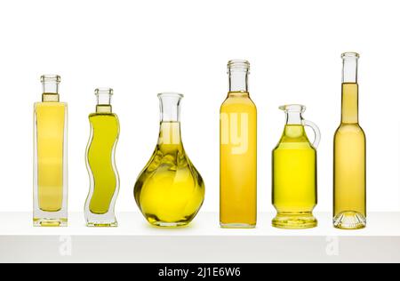 Variety of olive oils in bottles on white shelf, isolated on white background Stock Photo