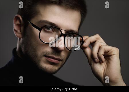 Young smart man wearing glasses and a folded polo neck Stock Photo