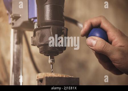 Carpenter is working on the drill machine Stock Photo