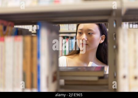 asian stylish young university school lady research student read book in library Stock Photo