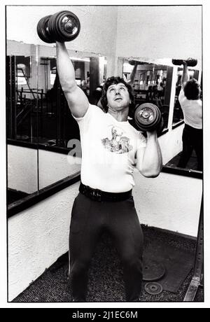 Al Oerter, four time Olympic winning gold medalist. In Long Island, New York lifting heavy weights at a gym. 1979 Stock Photo