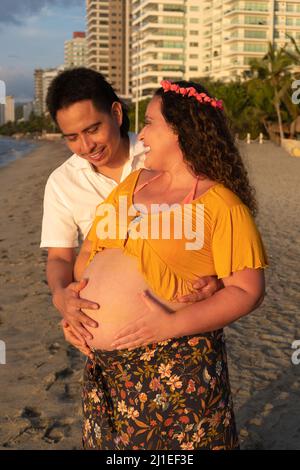 Couple expecting a baby while husband caresses the belly of his