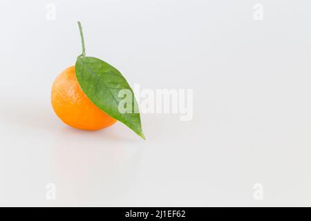 Ripe tangerine with green leaf. Orange citrus fruit isolated on a white background. Stock Photo