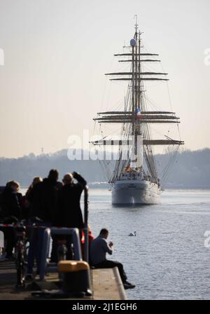 Kiel, Germany. 25th Mar, 2022. Relatives and friends greet the 'Gorch Fock' as it docks at the pier at the Kiel-Wik naval base. The navy's sail training ship returned to its home port after a four-month training voyage and moors backwards at the Gorch Fock pier. Credit: Christian Charisius/dpa/Alamy Live News Stock Photo