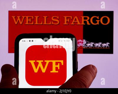 In this photo illustration, theWells Fargo Bank, N.A. logo is displayed on a smartphone screen with a Wells Fargo & Company logo in the background Stock Photo