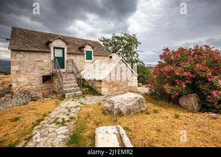 Old stone house with floral decoration on the forecourt, near Split town, Croatia, Europe. Stock Photo