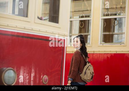 Young woman tourist standing between two slow-moving old trams - stock photo Stock Photo