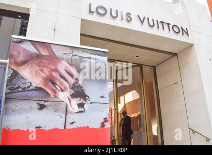 London, UK. 23rd March 2022. PETA activists wearing snake costumes and  covered in fake blood were 'skinned alive' outside the Louis Vuitton store  in New Bond Street in protest against the use
