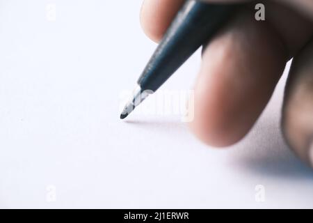 man hand writing on notepad while sited  Stock Photo