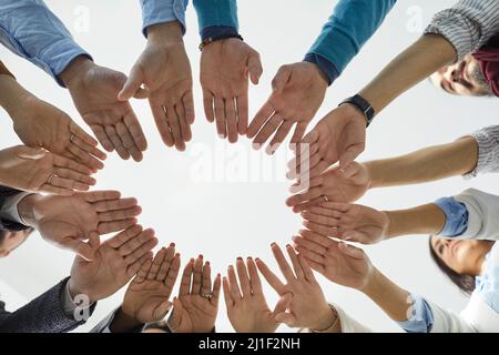Shot from below of diverse group of business people putting their hands together Stock Photo
