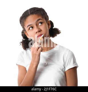 African-American teenage girl brushing her teeth on white background Stock Photo