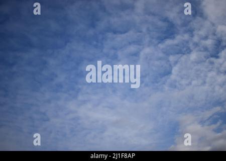 Fleecy clouds in blue sky. Cirrus clouds formation with blue sky background. Cirrus intortus Stock Photo