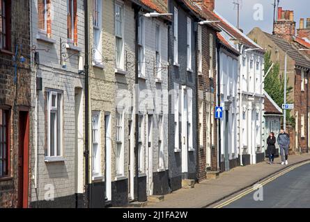 Young man and woman walking on Soutter Gate, Hedon, East Yorkshire, England UK Stock Photo