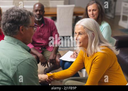 Caucasian senior man and woman talking during group therapy session Stock Photo