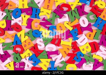 Colorful Bright Wooden Letters on pink Background. Back to school concept. Stock Photo