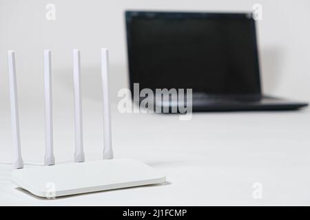Laptop and wi-fi router on a white background. Internet connection. Stock Photo