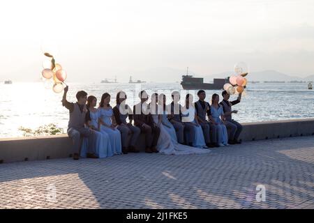 16 10 2021 friends and relatives take group photos with Bride and groom during wedding party near West Kowloon Waterfront Promenade, Hong Kong Stock Photo