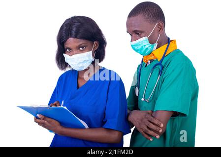 young teams of doctors in uniform with medical mask working together on the patient file of the hospital. Stock Photo