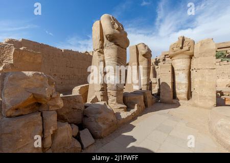 Three headless statues of Rameses II as Osiris, each holding two ankhs, in the Temple of Karnak Stock Photo