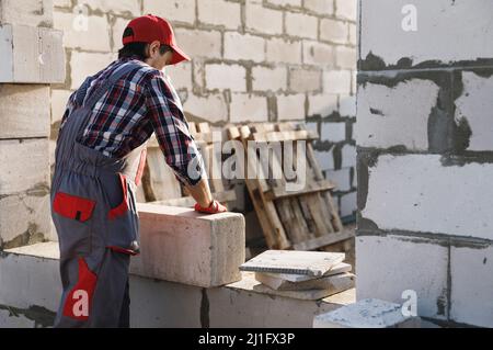 Bricklayer is working at the construction site Stock Photo
