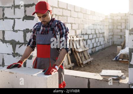 Bricklayer is working at the construction site Stock Photo