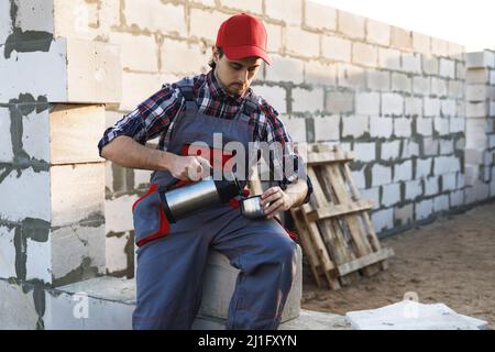 Bricklayer during the coffee break at the work Stock Photo
