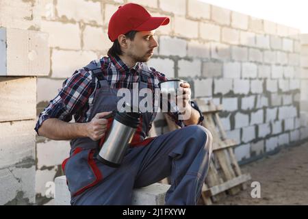 Bricklayer during the coffee break at the work Stock Photo