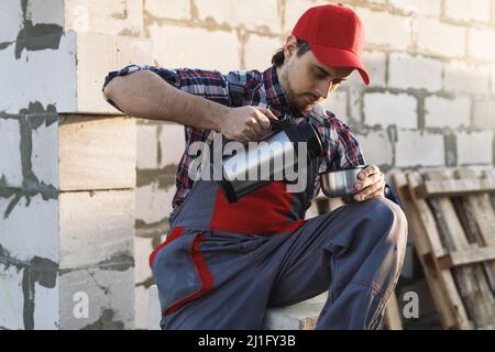 Bricklayer during the coffee break at the work Stock Photo